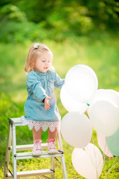 Маленька щаслива дівчинка з повітряними кулями — стокове фото