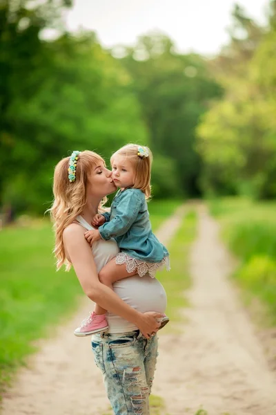 Femme enceinte avec jeune fille dans le jardin — Photo