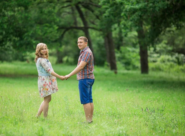 Gravid kvinna med sin man i trädgården — Stockfoto