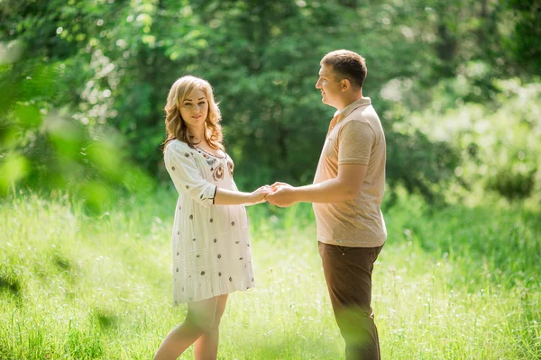 Pregnant woman with her husband in garden — Stock Photo, Image