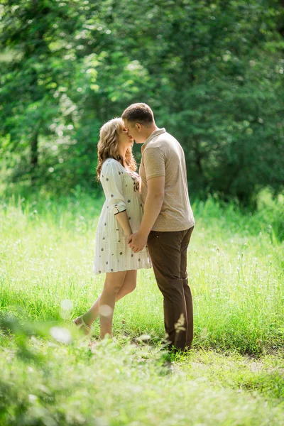 Gravid kvinna med sin man i trädgården — Stockfoto