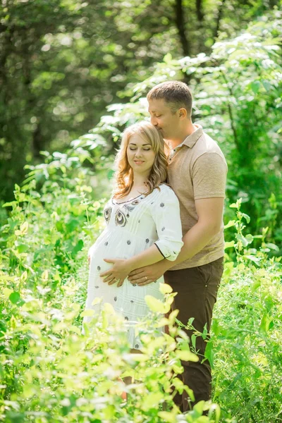 Donna incinta con il marito in giardino — Foto Stock