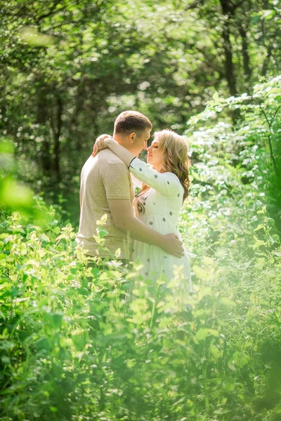 Mujer embarazada con su marido en el jardín —  Fotos de Stock