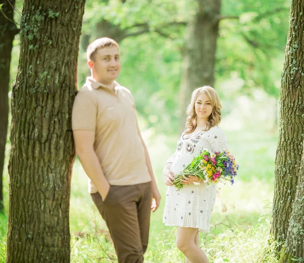 Donna incinta con il marito in giardino — Foto Stock