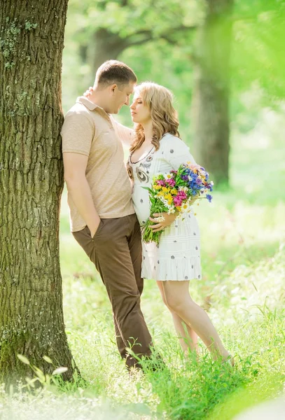 Zwangere vrouw met haar echtgenoot in de tuin — Stockfoto