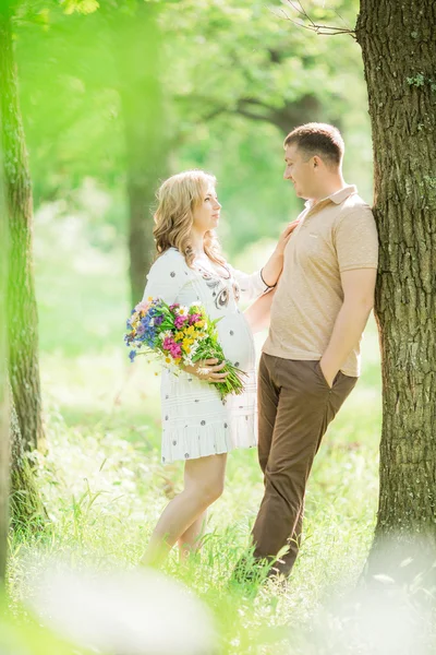 Mujer embarazada con su marido en el jardín — Foto de Stock