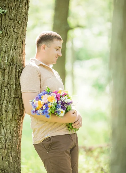 Jovem com um buquê de flores silvestres — Fotografia de Stock