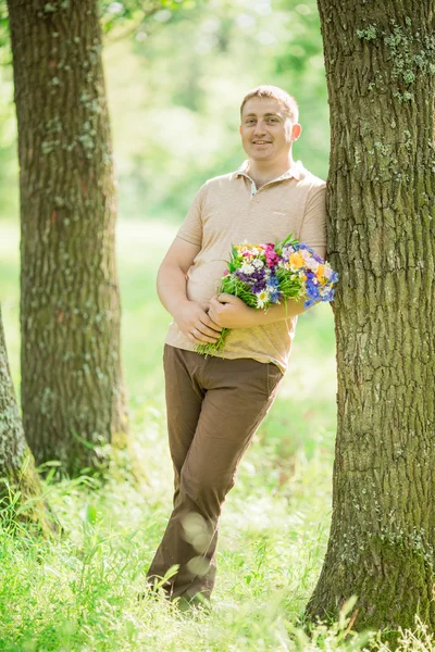 Jovem com um buquê de flores silvestres — Fotografia de Stock