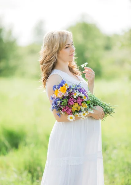 Femme enceinte avec un bouquet dans la nature — Photo
