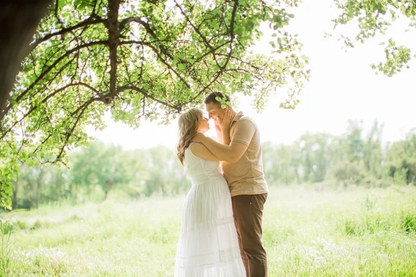 Pregnant woman with her husband in a field — Stock Photo, Image
