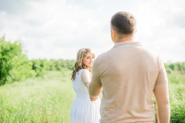 Donna incinta con il marito in un campo — Foto Stock