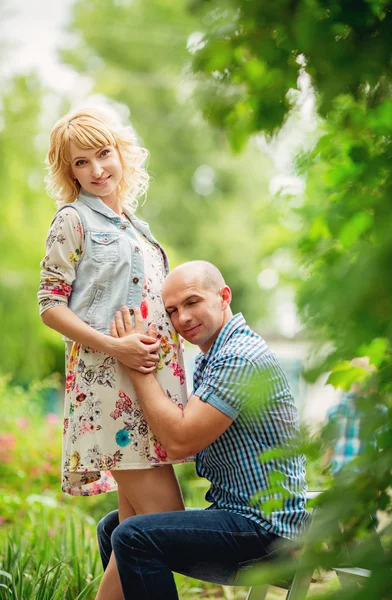 Gravid kvinna med sin man i trädgården — Stockfoto