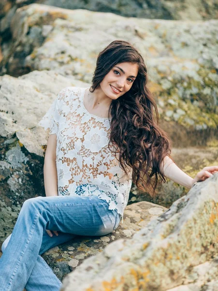 Beautiful woman on a background of stones — Stock Photo, Image