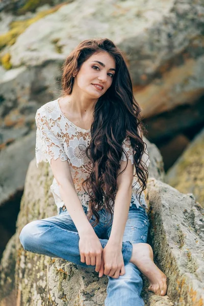 Beautiful woman on a background of stones — Stock Photo, Image