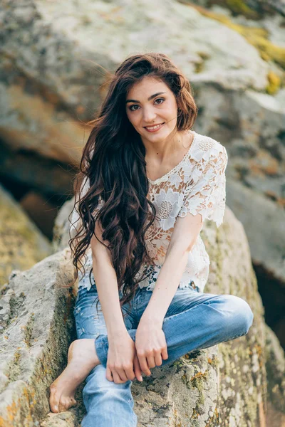 Beautiful woman on a background of stones — Stock Photo, Image