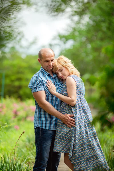 Gravid kvinna med sin man i trädgården — Stockfoto