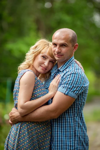 Gravid kvinne med sin mann i hagen – stockfoto