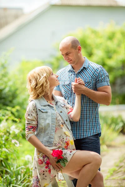 Zwangere vrouw met haar echtgenoot in de tuin — Stockfoto