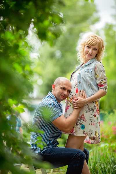 Femme enceinte avec son mari dans le jardin — Photo