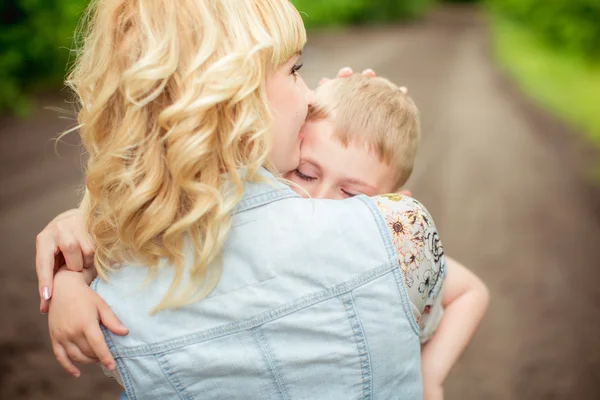 Femme enceinte avec jeune fils dans le jardin — Photo