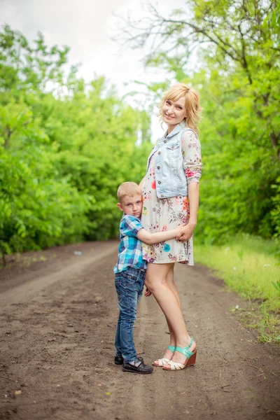 Donna incinta con giovane figlio in giardino — Foto Stock