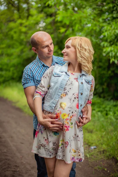 Schwangere mit Ehemann im Garten — Stockfoto