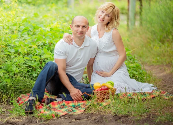 Mulher grávida com o marido no jardim — Fotografia de Stock