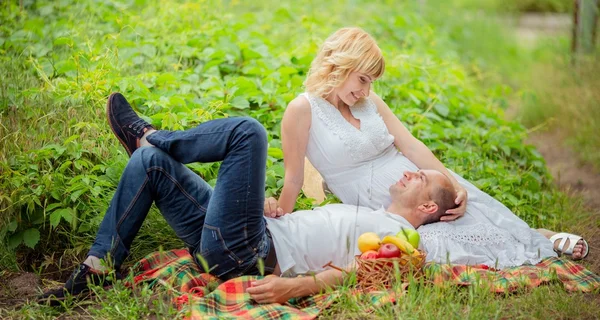 Zwangere vrouw met haar echtgenoot in de tuin — Stockfoto