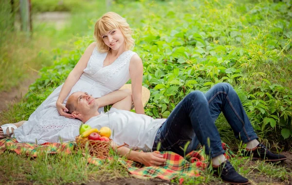 Donna incinta con il marito in giardino — Foto Stock