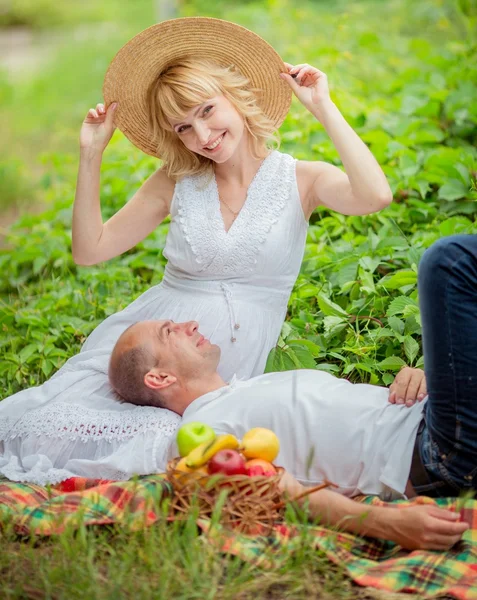 Zwangere vrouw met haar echtgenoot in de tuin — Stockfoto