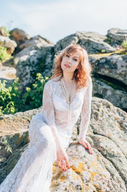 Taş zemin üzerine beyaz elbiseli kadın 