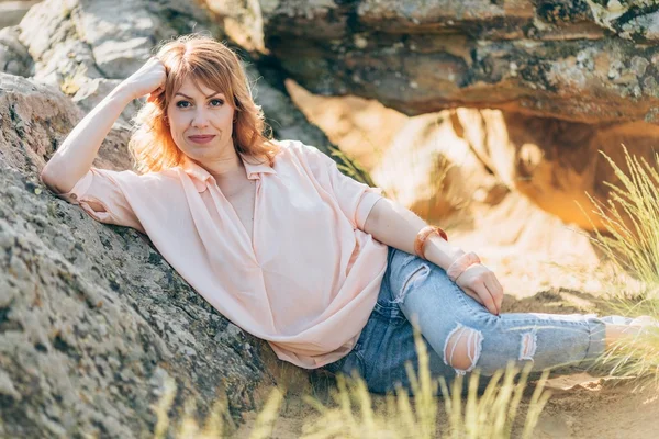 Beautiful woman on a background of stones — Stock Photo, Image