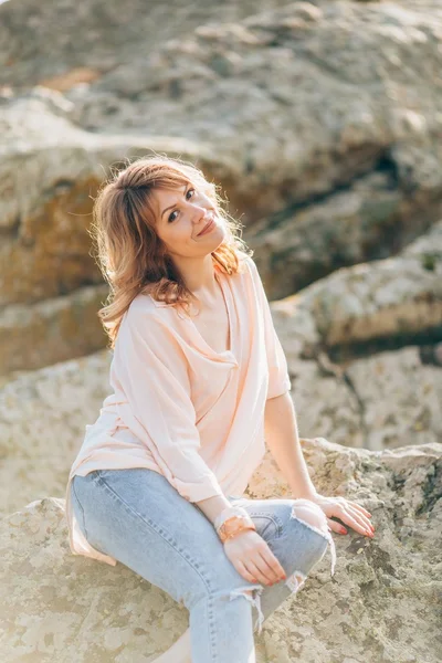Mooie vrouw op een achtergrond van stenen — Stockfoto