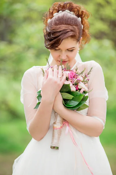 Schöne Braut im weißen Kleid mit Strauß — Stockfoto