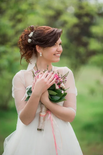 Belle mariée en robe blanche avec bouquet — Photo