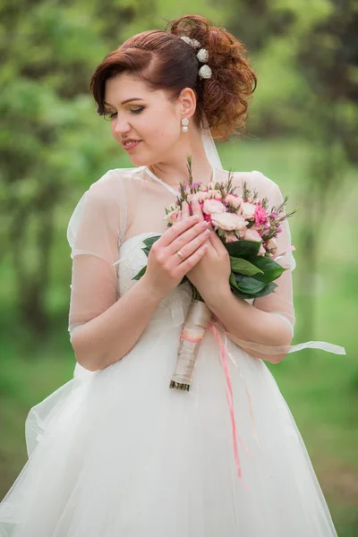 Belle mariée en robe blanche avec bouquet — Photo