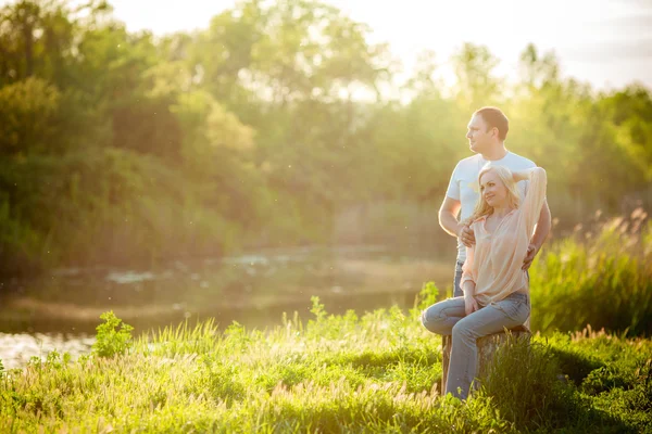 Jovem casal no gramado do parque — Fotografia de Stock