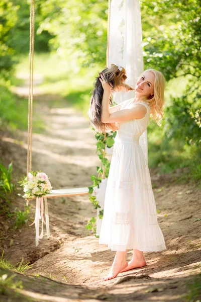 Vrouw in lentetuin met hond — Stockfoto