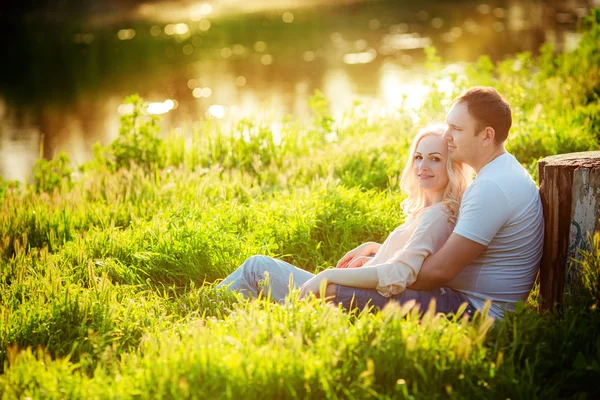 Pareja joven en el césped del parque — Foto de Stock