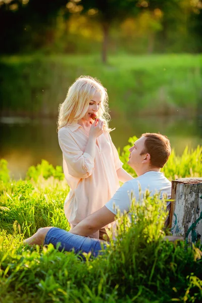 Jovem casal no gramado do parque — Fotografia de Stock