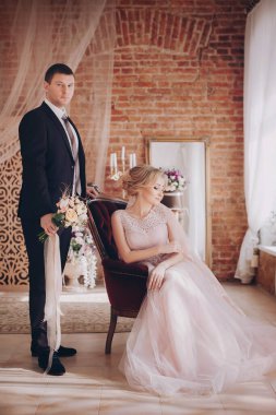 Güzel gelin ve damat stüdyoda poz veriyor.