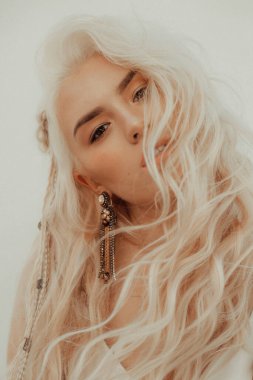 Boho tarzında beyaz elbiseli güzel bir sarışın portresi.