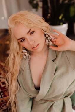 Boho tarzında beyaz elbiseli güzel bir sarışın portresi.