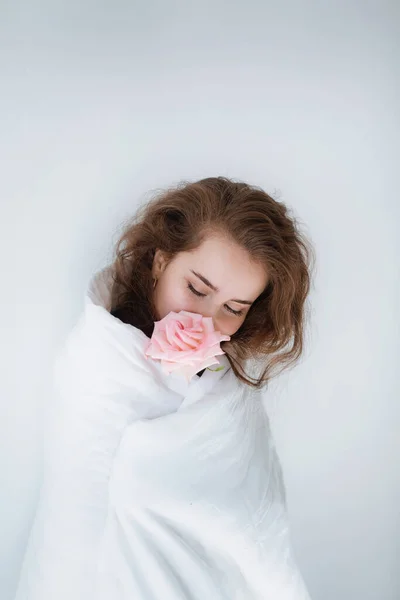 库存照片 甜女孩与粉红玫瑰在她的床的盖下 — 图库照片