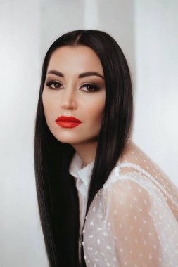 Uzun, siyah saçlı, güzel bir genç kadın. 