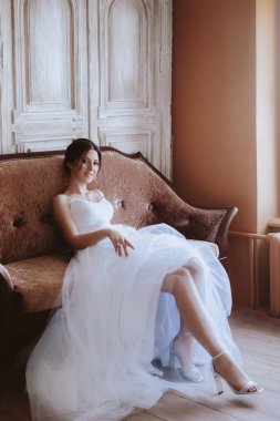 Beyaz elbiseli güzel gelin stüdyoda poz veriyor.