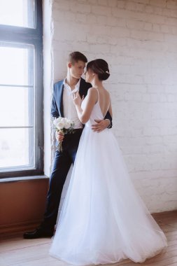 Güzel gelin ve damat stüdyoda poz veriyor.