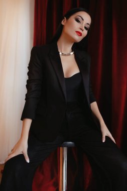 Siyah ceketli kadın stüdyoda poz veriyor.