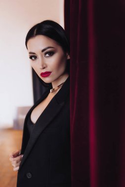 Siyah ceketli kadın stüdyoda poz veriyor.