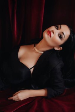 Siyah ceketli kadın stüdyoda poz veriyor.